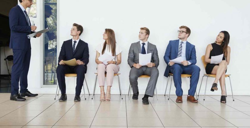 Hiring manager addressing executive interviewees in a waiting room